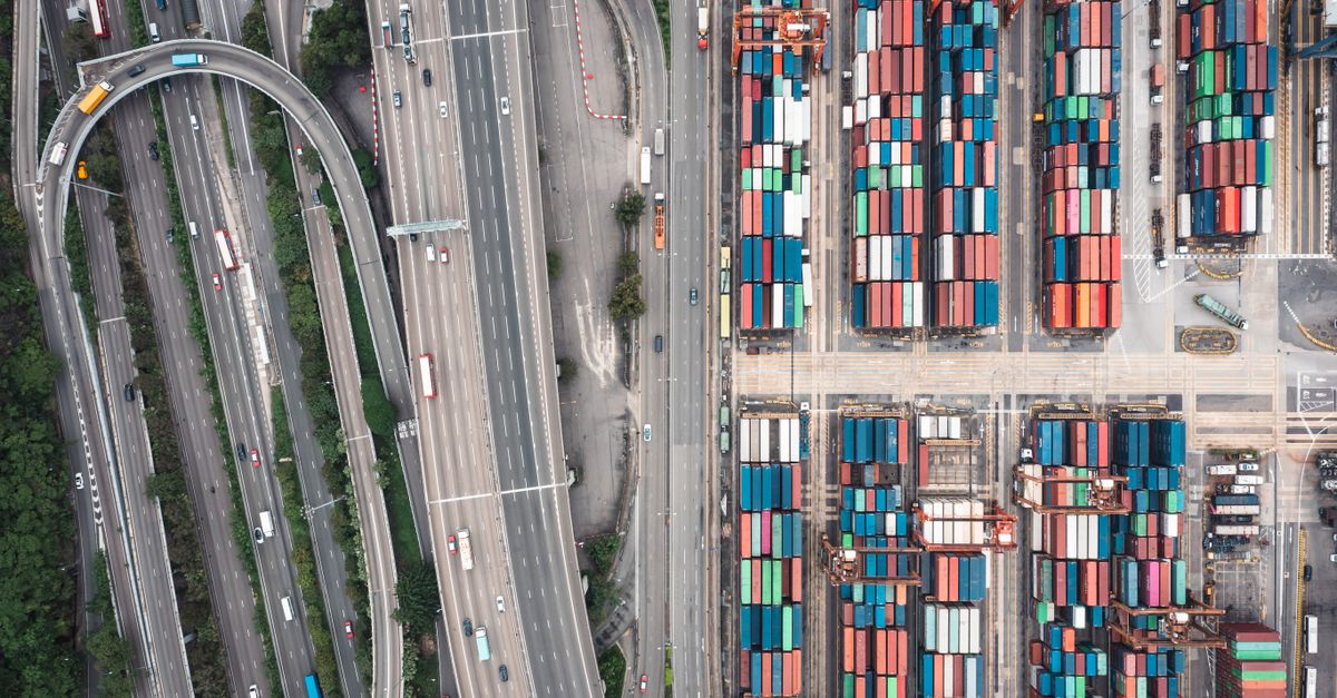 Aerial shot of Hong Kong's shipping containers and highway interchange showcasing urban logistics.